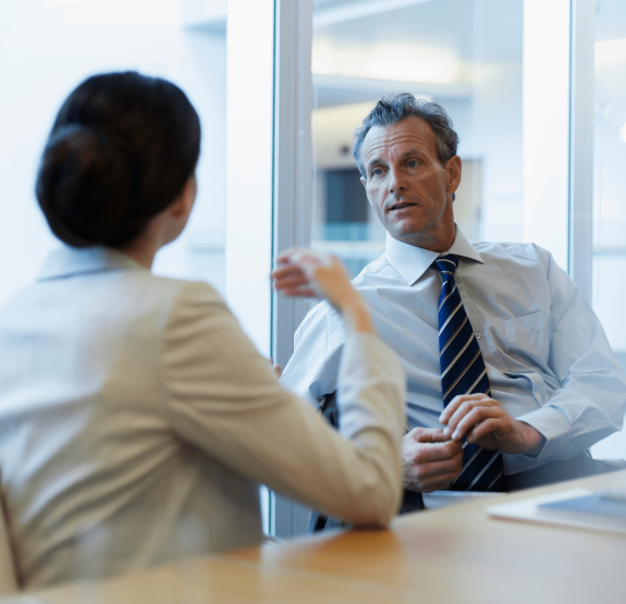 Man speaking with a woman in a conference room